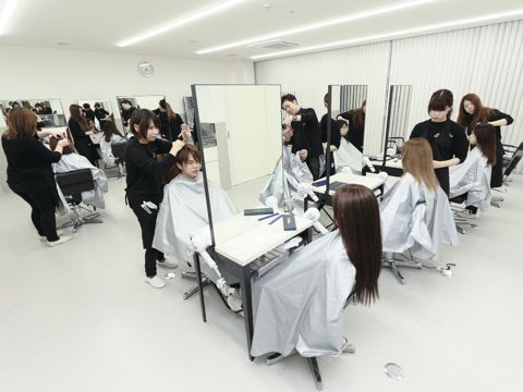 【長堀校舎：ヘアメイクルーム】交代で実践しヘアメイクの技術を磨きます。